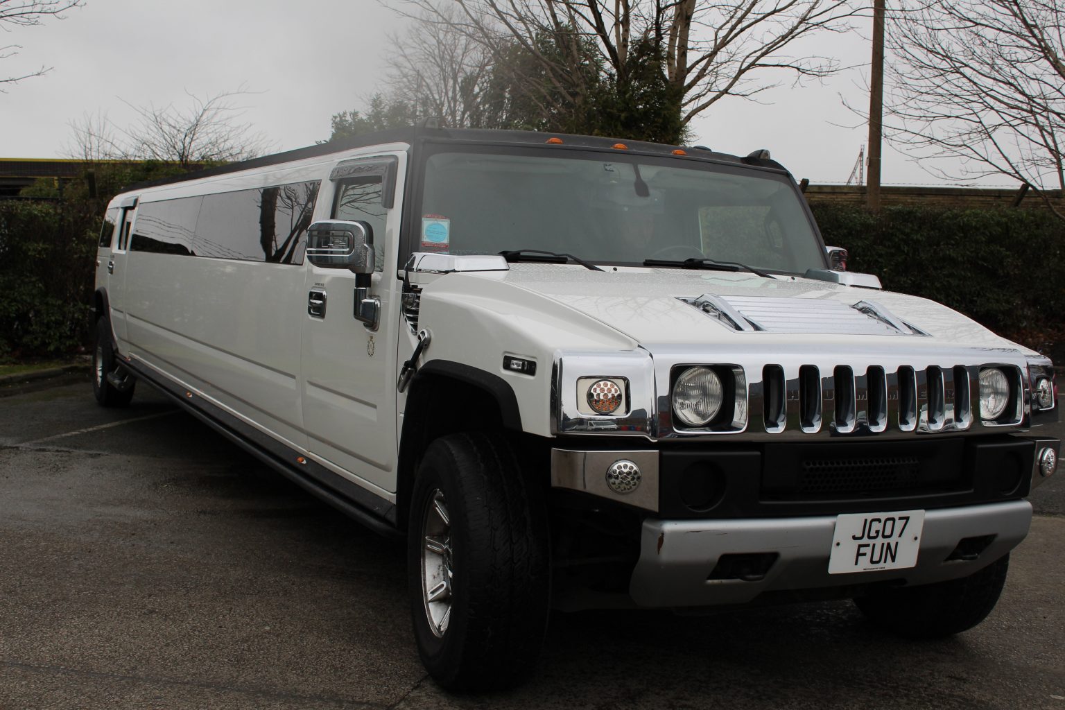 White stretch Hummer H2 limousine on a driveway