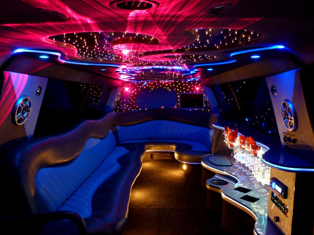 Limousine interior with pink lighting and a starlit ceiling