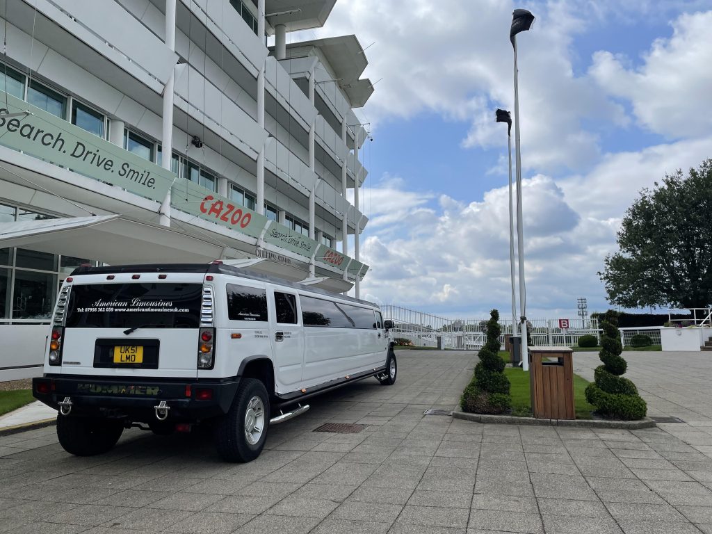 White stretch Hummer limousine with ribbons at a summer event