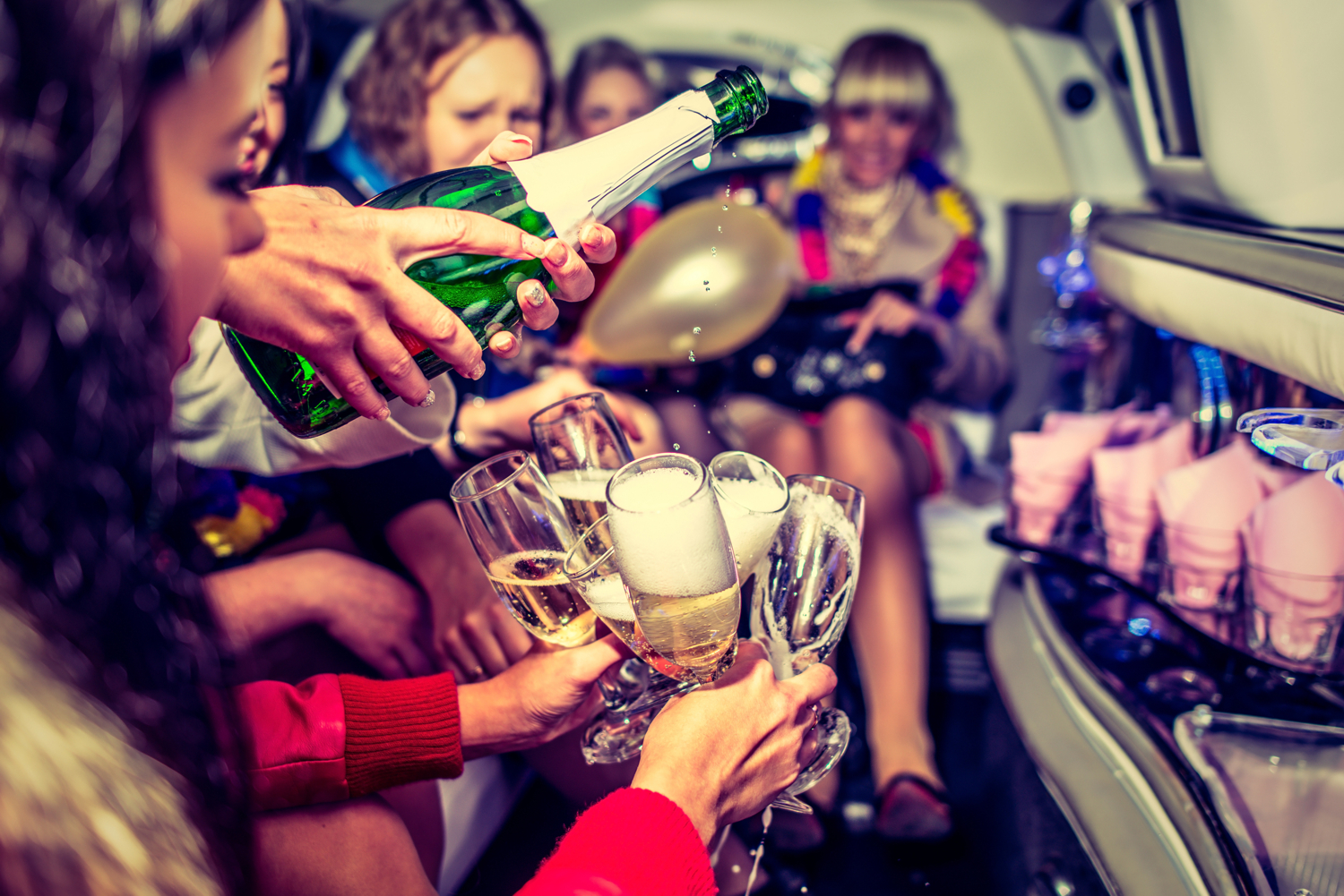 Hen party celebrating with drinks inside a limousine