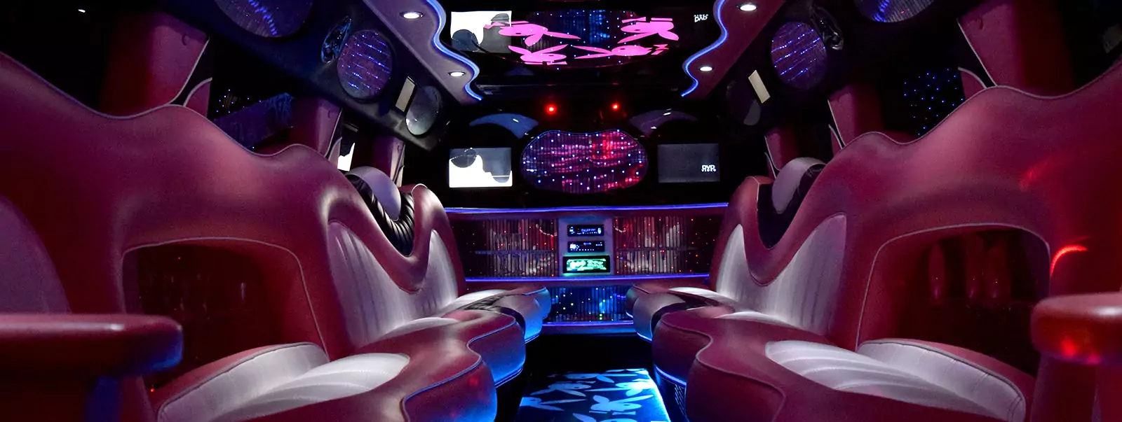 Pink limo interior with white leather seats and pink mood lighting